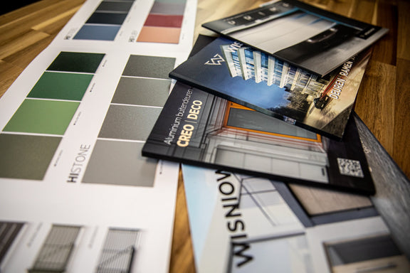 Wiśniowski-brochures en RAL-kleurstalen op een werkbank