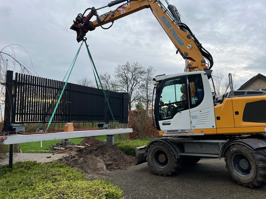 Werkzaamheden aan een hekwerk met materieel